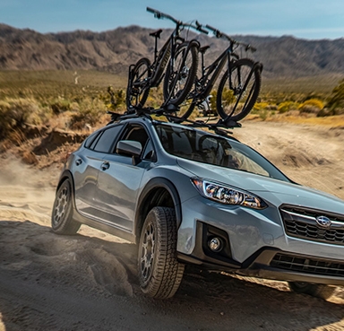 Subaru Crosstrek driving down a rough dirt trail.