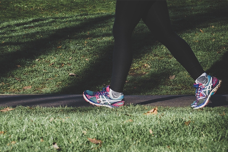 woman's legs walking on sidewalk.