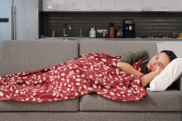 Woman napping on a gray couch