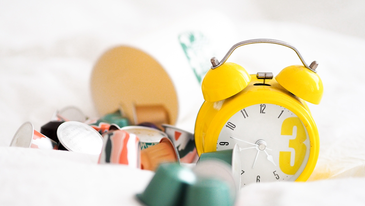 A yellow analog alarm clock with bells