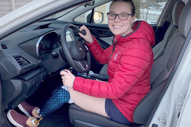 Morgan Stickney seated behind the steering wheel of her Subaru Crosstrek Sport. 