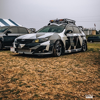 A decked-out Subaru performance vehicle in a black, gray and white pattern at FL4TFEST