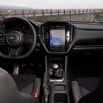 A shot of the 11.6-inch tablet, steering wheel and six-speed manual taken from the back seat.