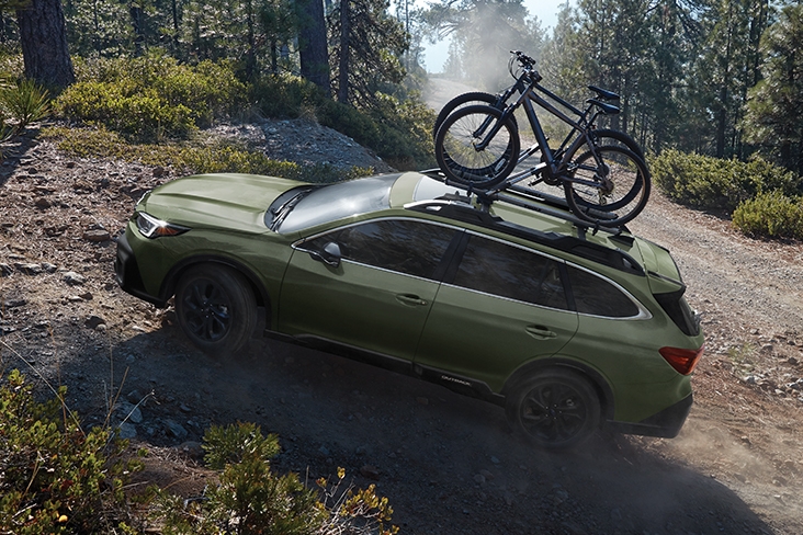 2021 Subaru Outback Onyx Edition XT in Autumn Green Metallic driving uphill on a dirt trail