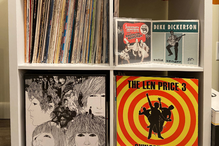 A picture of Craig Fitzgerald's vinyl collection, which is stored in a shelving unit with four sections. On the lower section to the right, the album Revolver by the Beatles is facing outward.