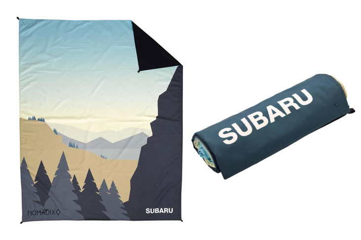 The blanket features a mountain sunrise illustration with a neutral palette and blue sky.