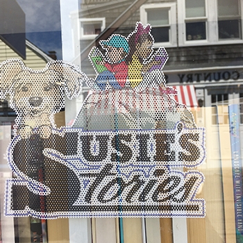 A closeup of the business name, Susie’s Stories, on a window.