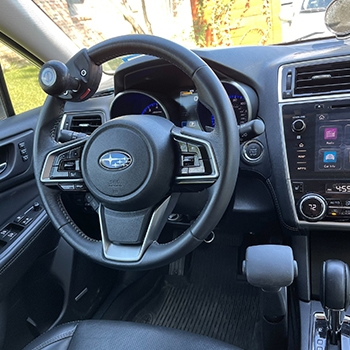 The steering wheel showing an alternative spinner knob option. The spinner knob helps to make turning easier for someone who is steering with one hand.