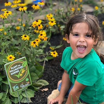 Feldkamp’s son smiling next to a bed of black-eyed Susan’s