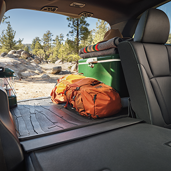 Cargo area of the Subaru Forester Wilderness shown with a bag, ice chest, blankets and other items packed for an adventure.