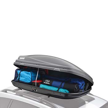 A Thule Cargo Carrier is attached to the rooftop of a Subaru. It is open and packed with several bags showing how much it can hold when full.