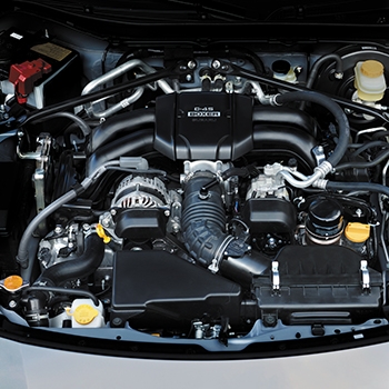 A view under the hood of a 2022 Subaru BRZ showing the new engine in black.