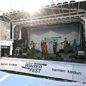 A band plays on stage during sunset at WinterFest.