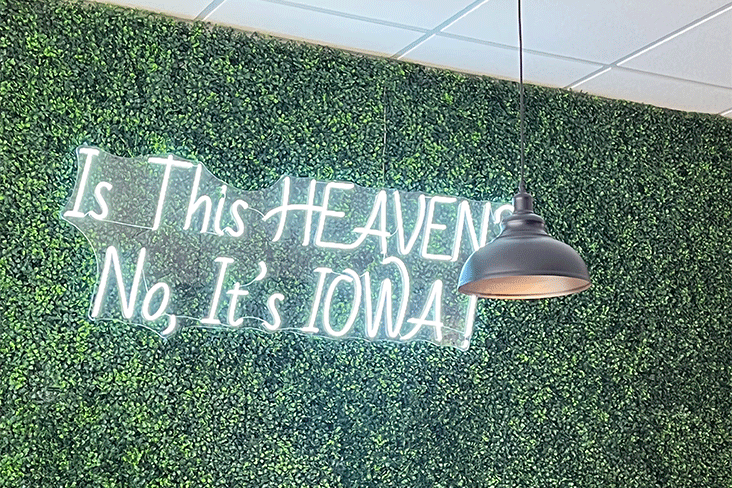 A neon sign spelling out Is This HEAVEN? No, It's IOWA!