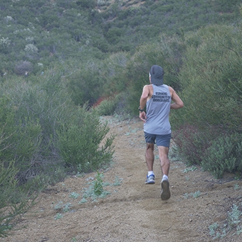 Ruperto Romero, as seen from behind, running on a trail segment.