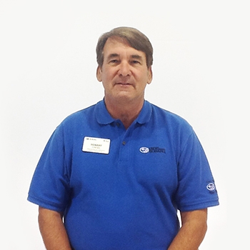 A headshot of H. R. Hicks. He is wearing a blue Subaru shirt and is smiling.