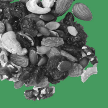 A black-and-white image of a pile of trail mix with raisins, cashews, almonds and walnuts on a green background