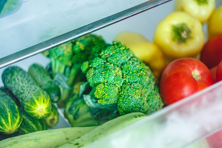 Fresh produce in a clear drawer of a fridge