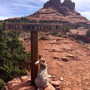 Baby-to-be’s plush jack rabbit sitting on the Bell Rock trailhead marker in Sedona, Arizona.