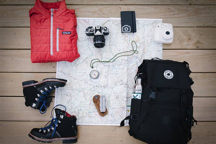 Camping gear, including a camera, boots, backpack and vest