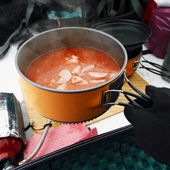 Closeup of a pan filled with food that is piping hot.