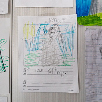 A child’s drawing showing a mountain with a person climbing with the words “I can climb.”