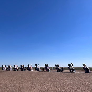 10 half-buried Cadillas seen from a distance at the Cadillac Ranch.