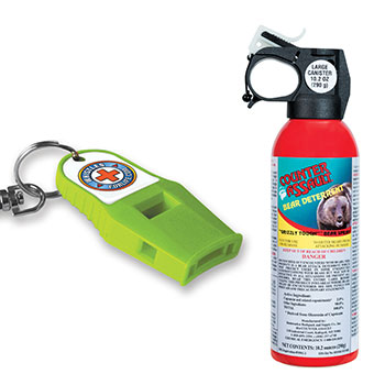 A sturdy-looking, lime-green whistle on a keychain on the left and a red canister of bear deterrent spray on the right.