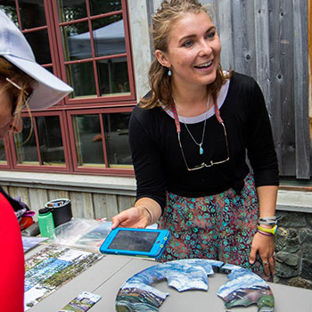 Artist Mariah Reading talking to visitors at the Denali Visitor Center