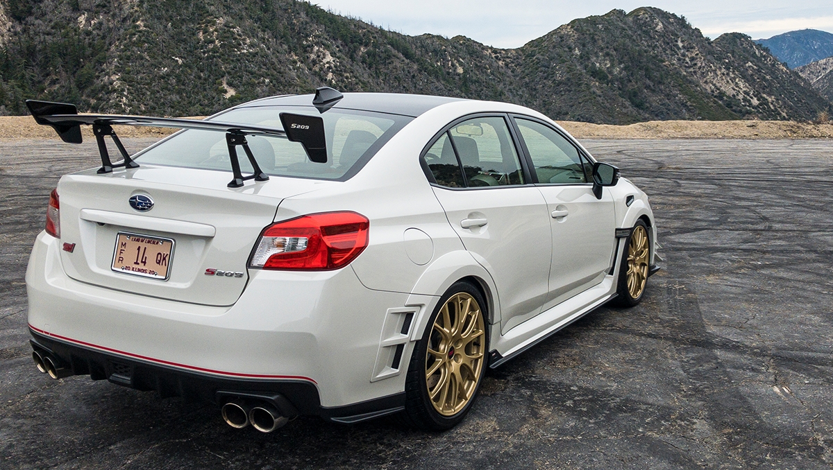 A 2020 Subaru WRX STI S209 from the rear, showing the wing and rear quarter, and the mountains in the background