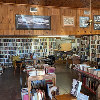 View of a room at Booked up, with a paneled wall in the upper half and rows of books below it.