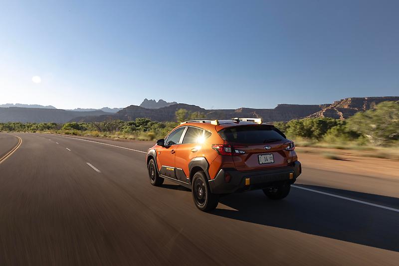 Rear view of 2024 Subaru Crosstrek Wilderness driving on a stretch of Utah highway