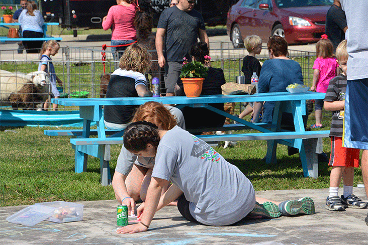 The turquoise table on Kristin Schell’s front lawn with several people gathered around it.