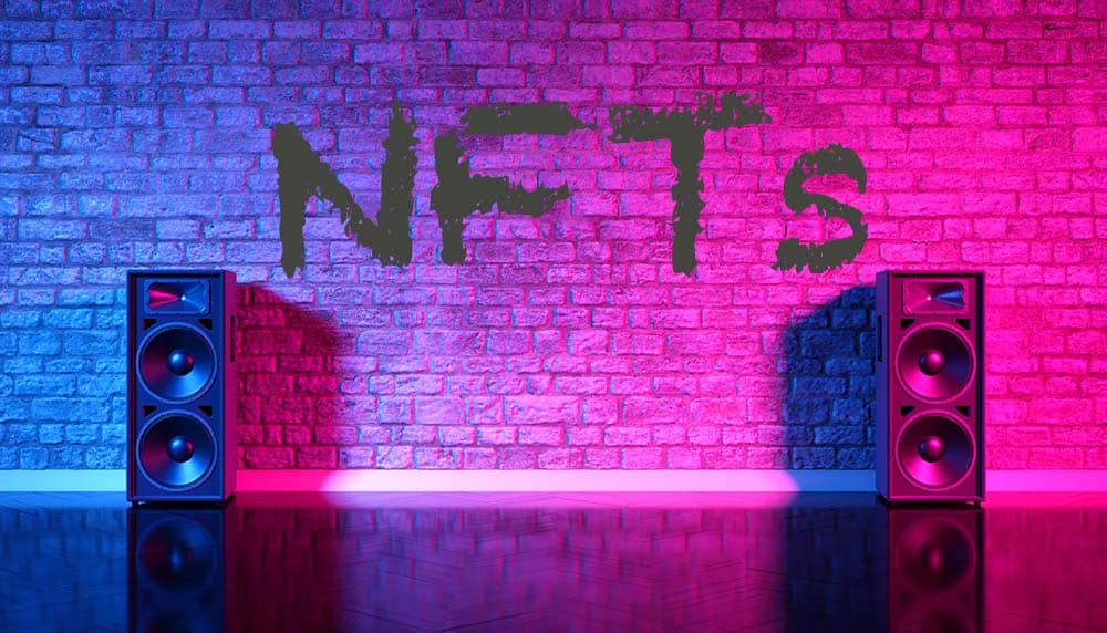 The word “NFTs” painted on a wall in between two stereos