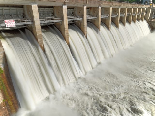 A photograph of water rushing down a dam A photograph of water rushing down a dam