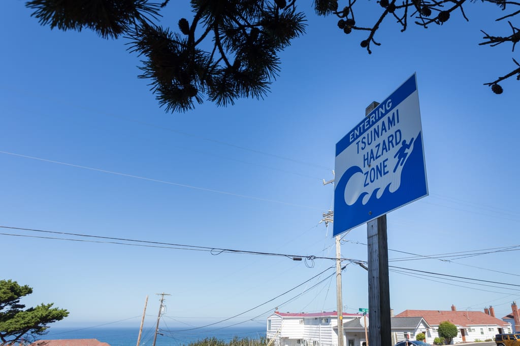 A tsunami warning sign along a coastal highway near the Oregon coast. A tsunami warning sign along a coastal highway near the Oregon coast.