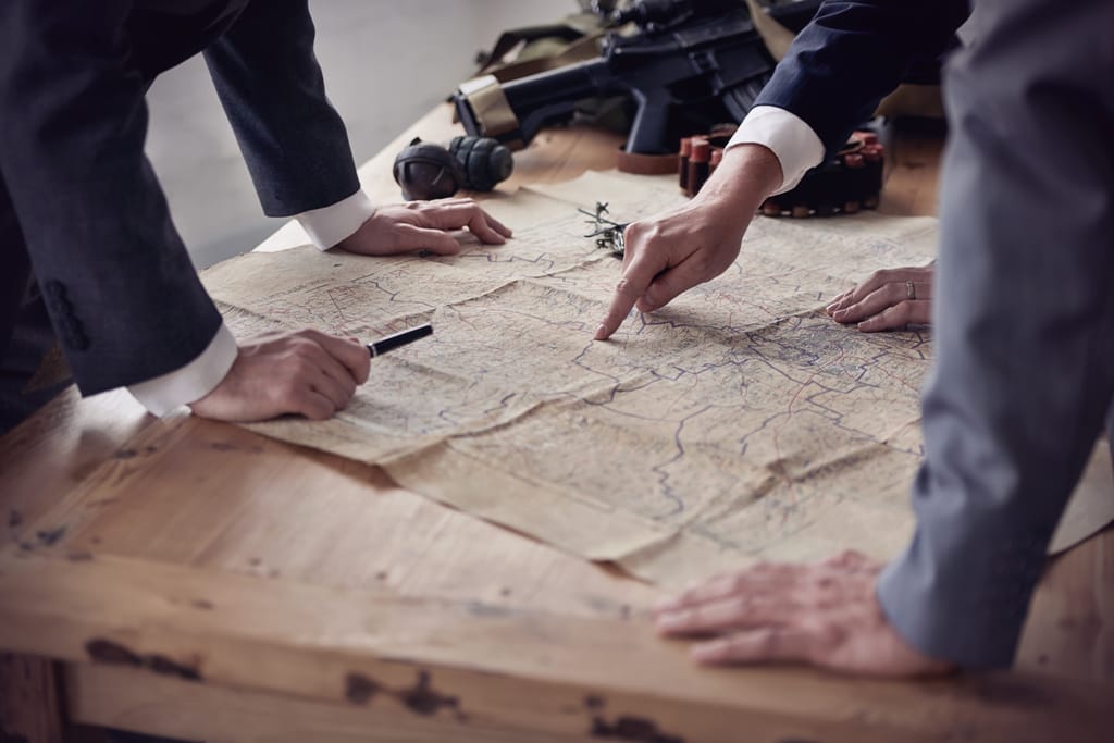 An illustration showing multiple hands on a printed map An illustration showing multiple hands on a printed map