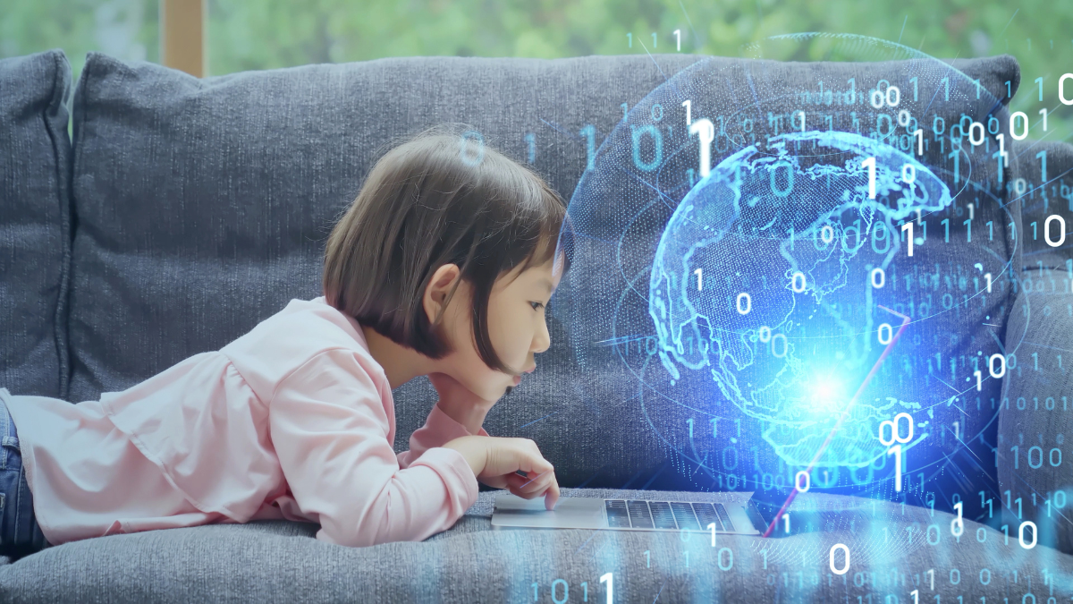 Girl on sofa looking at laptop with digital globe image extending from laptop