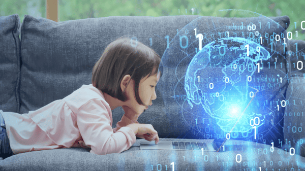 Girl on sofa looking at laptop with digital globe image extending from laptop Girl on sofa looking at laptop with digital globe image extending from laptop