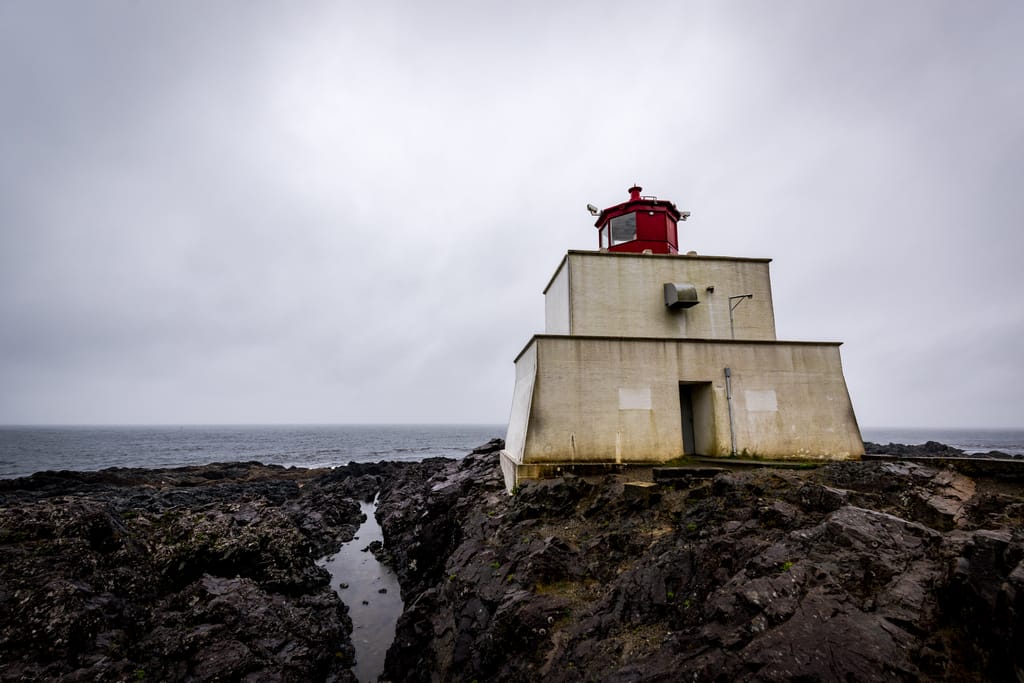 A lighthouse on a rocky coast, with an overcast sky A lighthouse on a rocky coast, with an overcast sky
