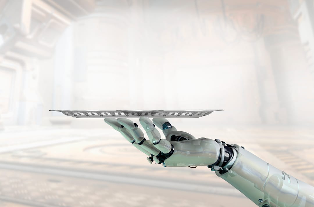 A silver-white robot hand holding a silver tray on its fingertips, against a blurred background of a large room