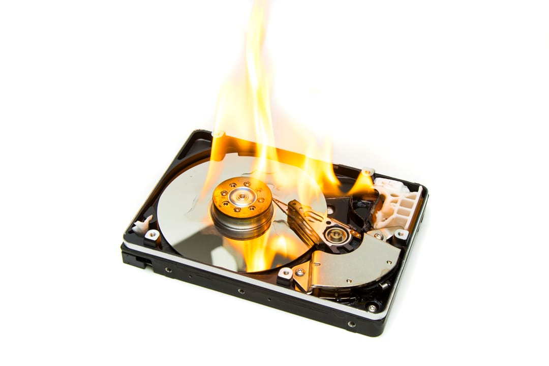 A computer hard disk on fire against a white background