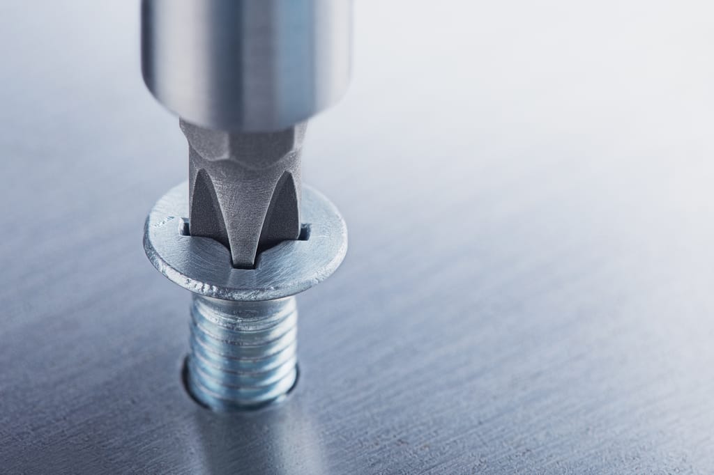 Un destornillador apretando un tornillo Un destornillador apretando un tornillo