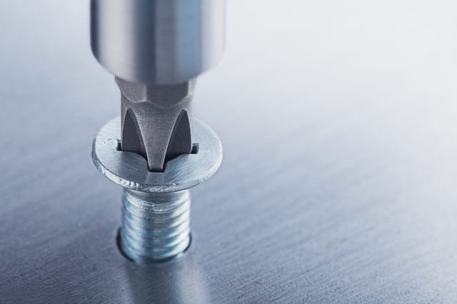 Un destornillador apretando un tornillo Un destornillador apretando un tornillo
