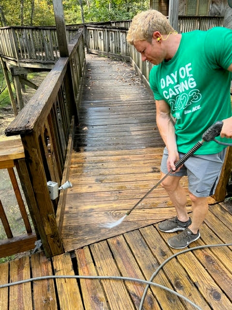 CBL team member Mike Oswald pressure washes a boardwalk at Reflection Riding during United Way Day of Caring in 2023.