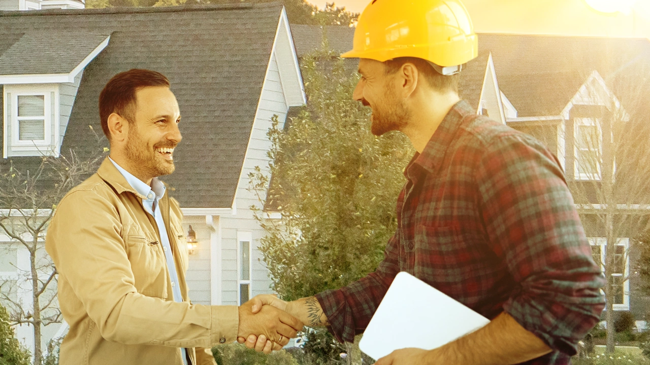 A roofer smiling and shaking hands with a customer.