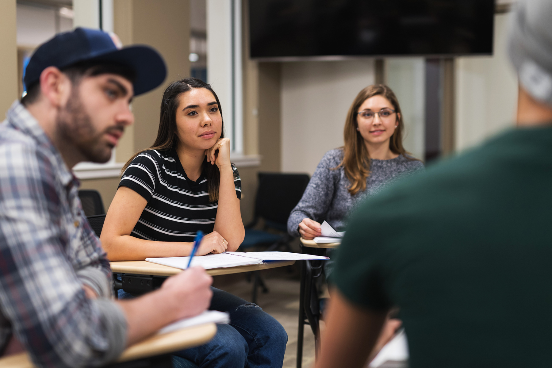 Tres estudiantes hablando con el profesor