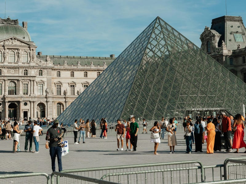 Personas caminando en París mientras piensan en estudiar con un curso de francés.