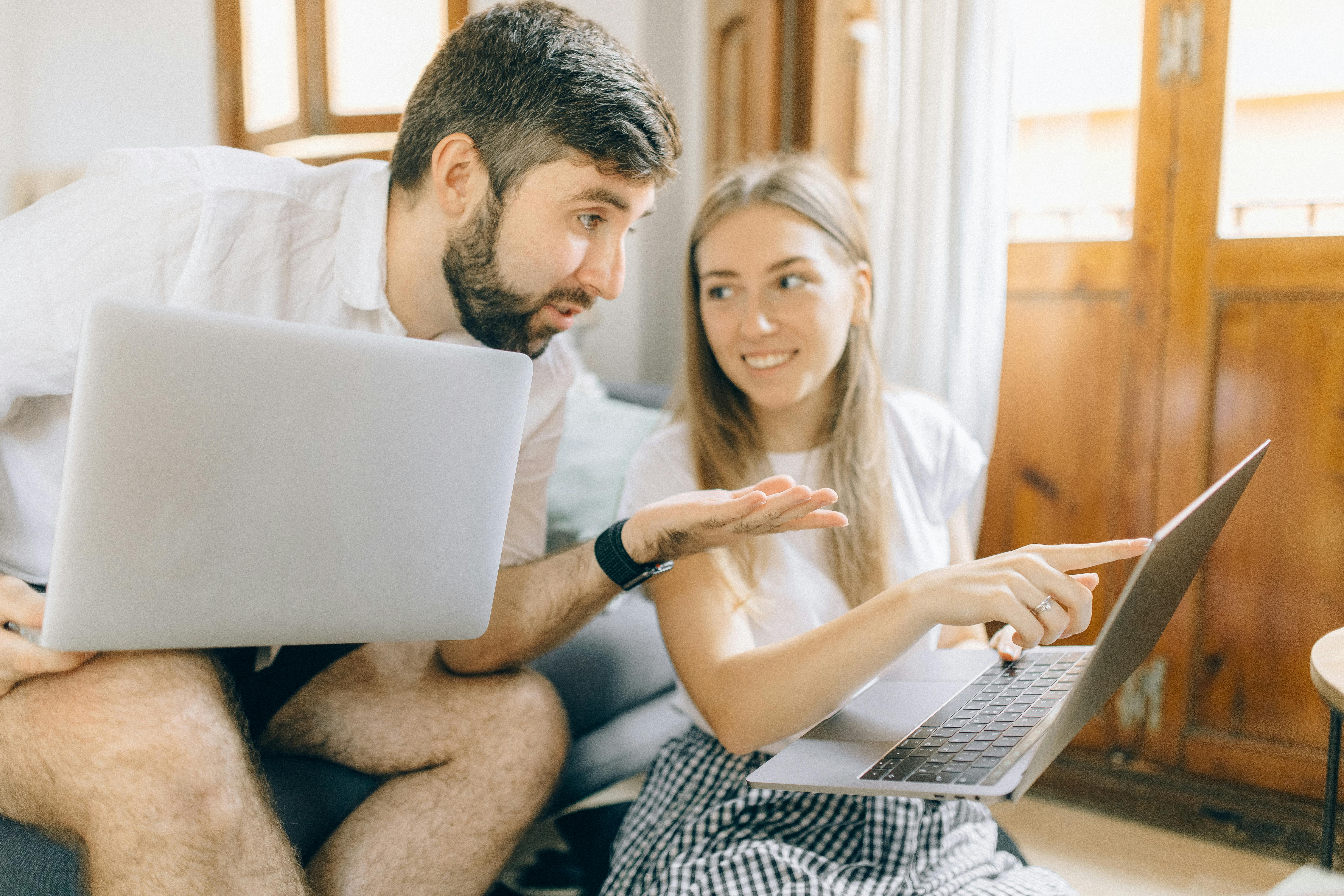 Hombre y mujer sentados frente a una laptop cada uno para estudiar el nivel básico de inglés.