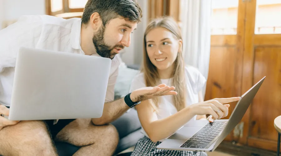 Hombre y mujer sentados frente a una laptop cada uno para estudiar el nivel básico de inglés.